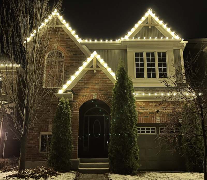 Professional Christmas light installation on a home — custom-fit roofline lighting