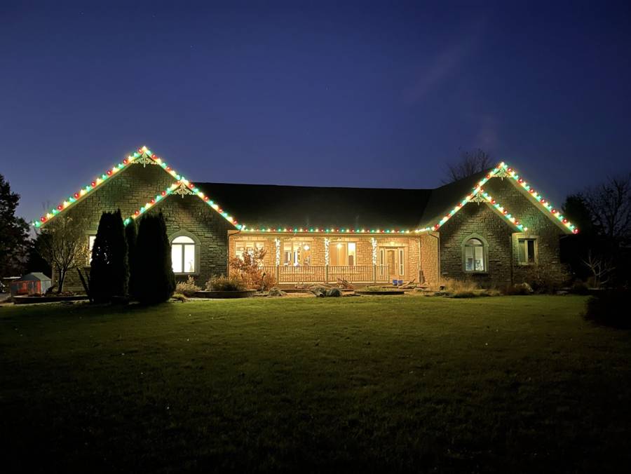 Professional Christmas light installation on a home — custom-fit roofline lighting