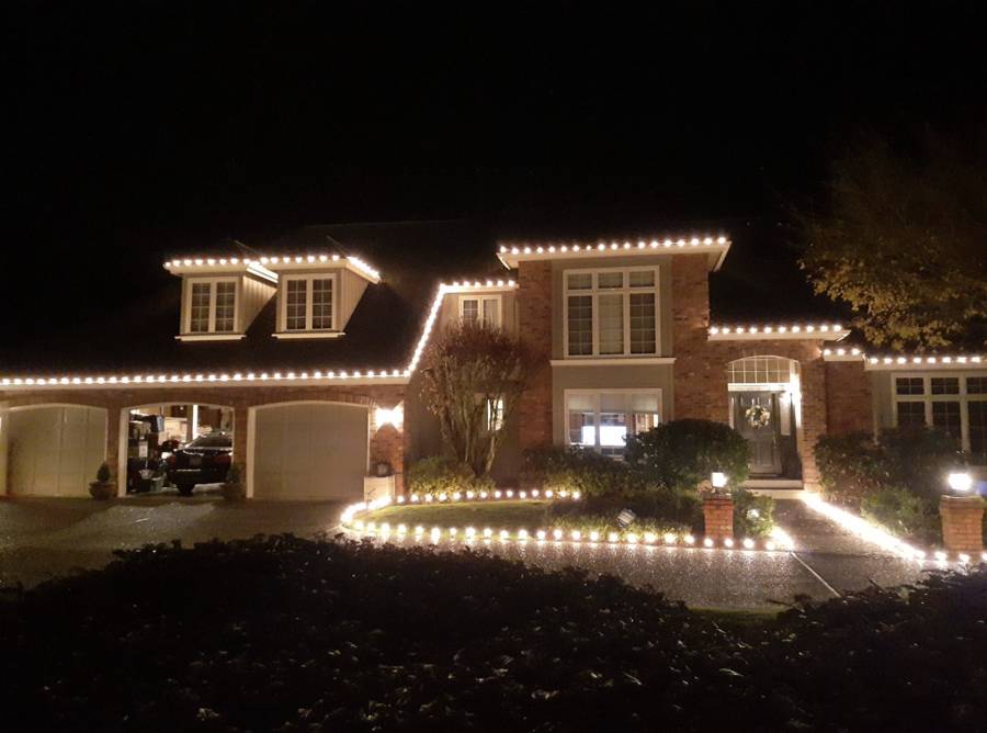 Professional Christmas light installation on a home — custom-fit roofline lighting